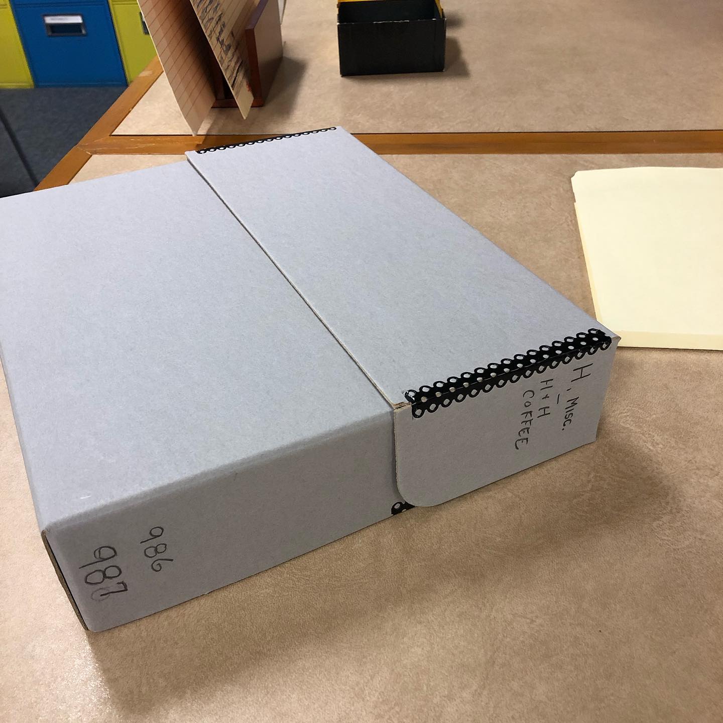 Archival flip-top box from the UTSA Institute of Texan Cultures — handwritten label "H., Misc. — H + H Coffee", Zintgraff Collection items 986–987.