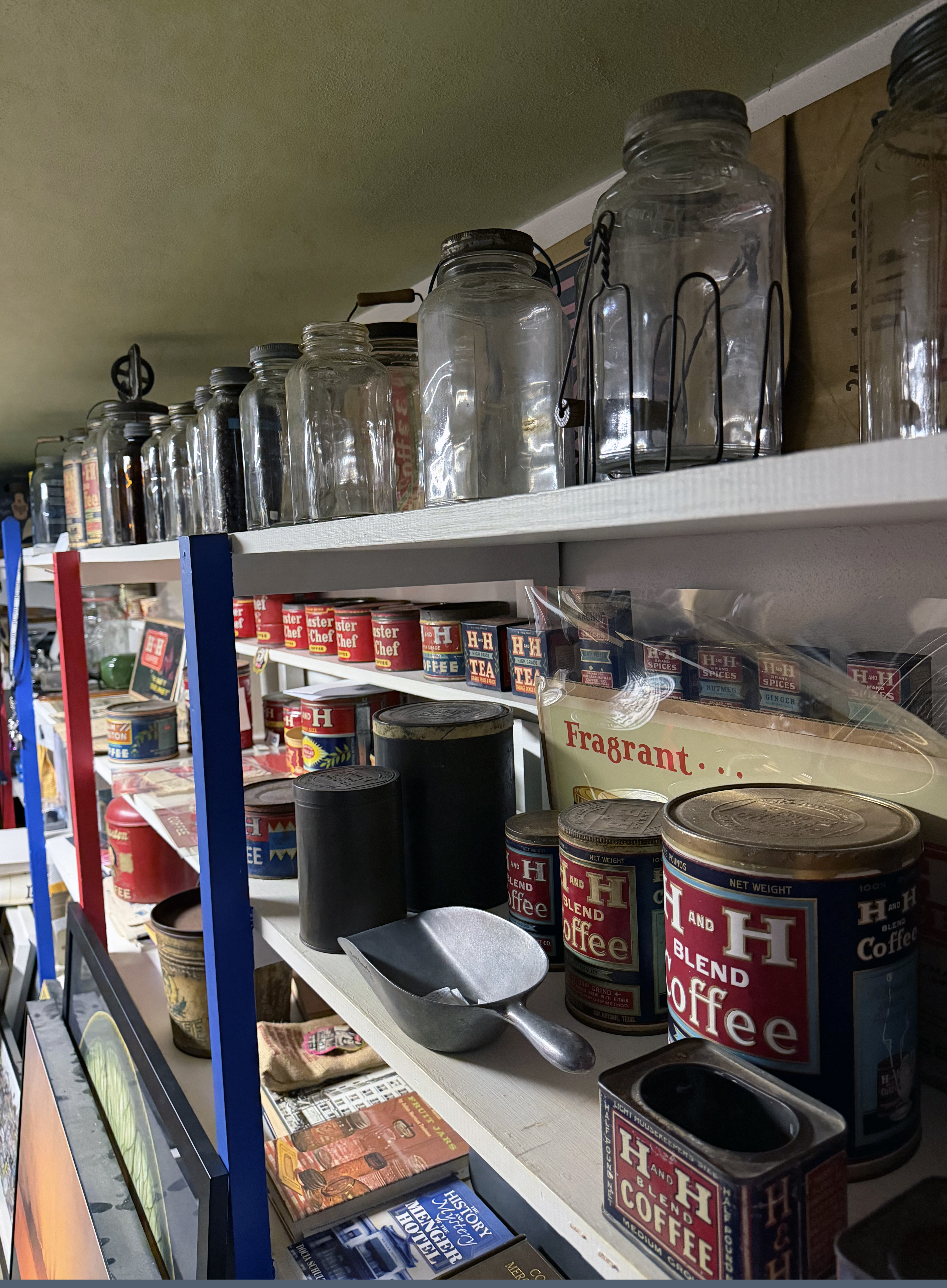 H and H collection arranged across lined shelves, Crystalvac jars up top and H and H tins below